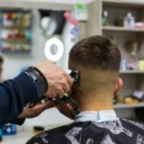 Mand der får klippet hår i barbershop