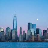 Manhattan skyline med One World Trade Center set fra vandet ved skumring