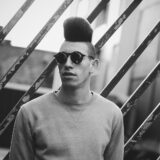 Mand med moderne hårfrisure og solbriller