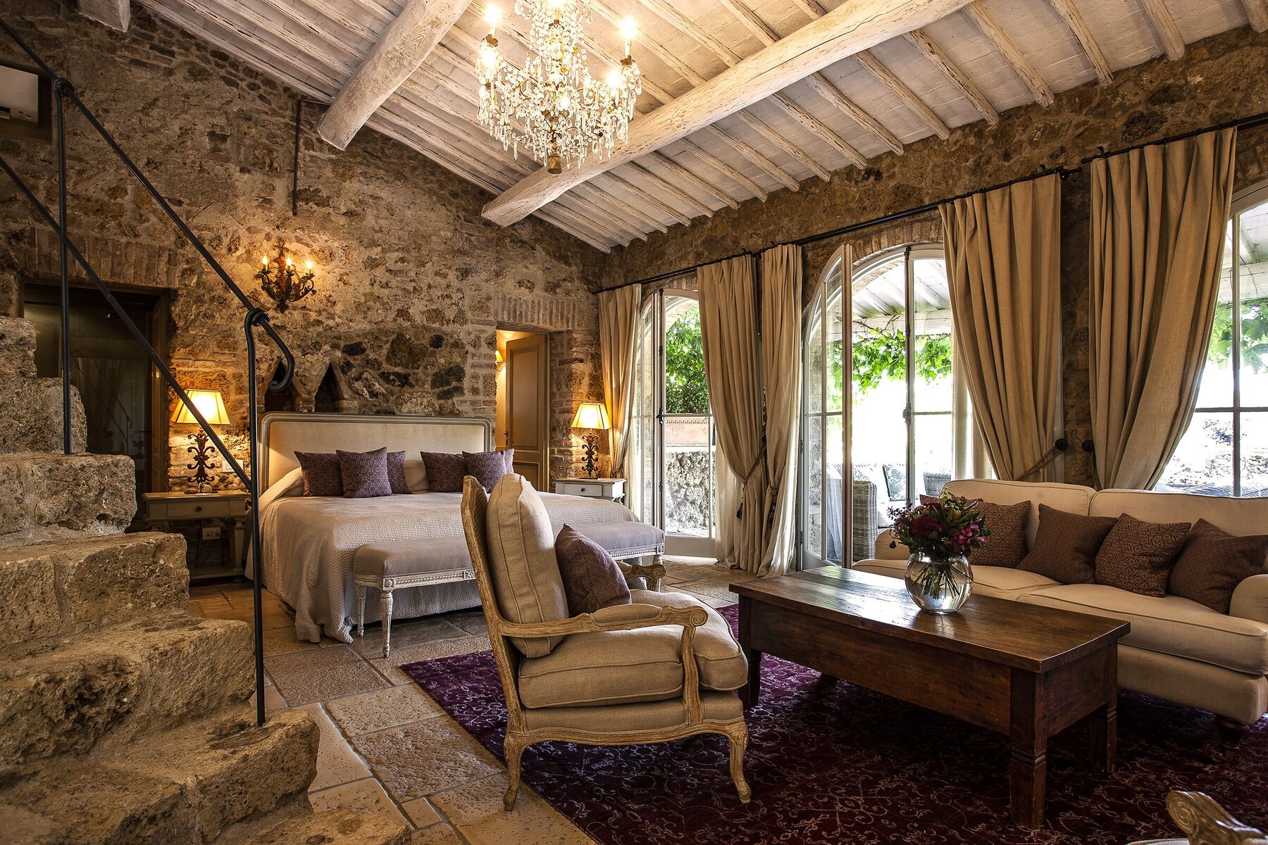 Suite med stenvægge og lysekrone på Borgo Santo Pietro