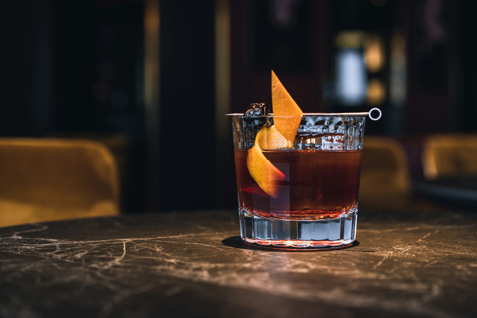 Old Fashioned cocktail i moerkt bar