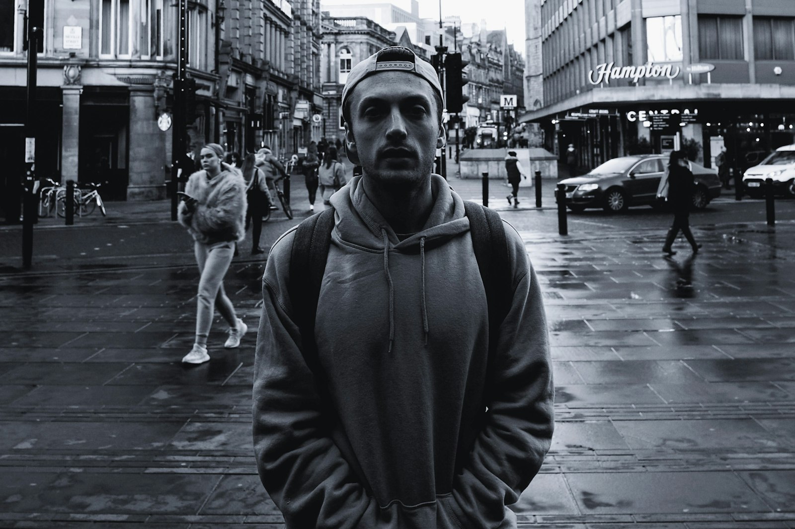Mand i grå hoodie på våd bygade, editorial streetstyle