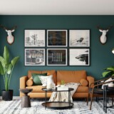 Mørkegrøn vægfarve i stue med læder-sofa og sort-indrammet kunst