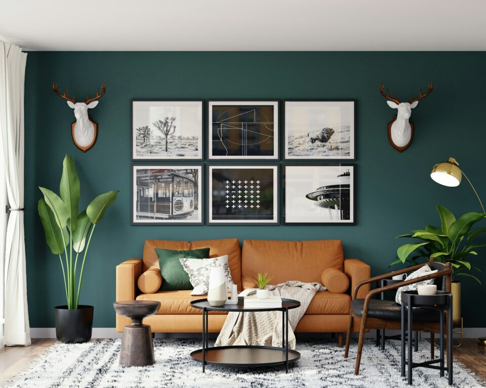 Mørkegrøn vægfarve i stue med læder-sofa og sort-indrammet kunst