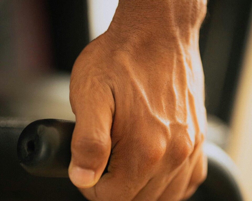Hånd der griber træningsudstyr med tydelige blodårer