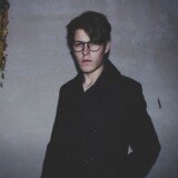 Mand i sort blazer med briller, moody editorial portræt