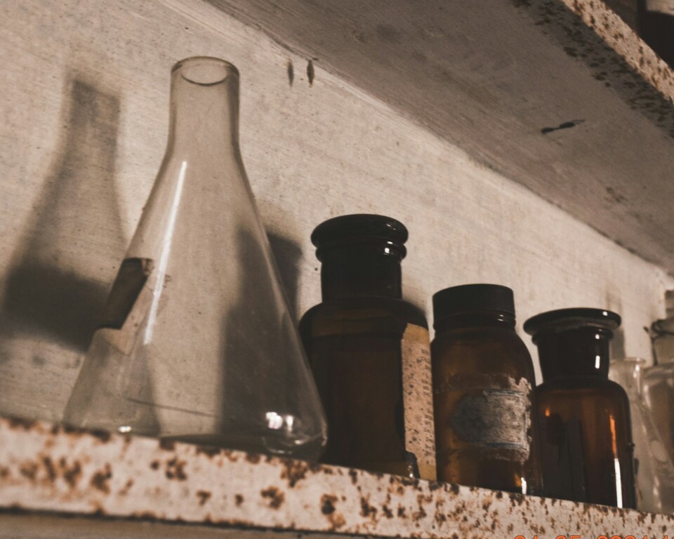 Vintage laboratorium med glasflasker på træhyld
