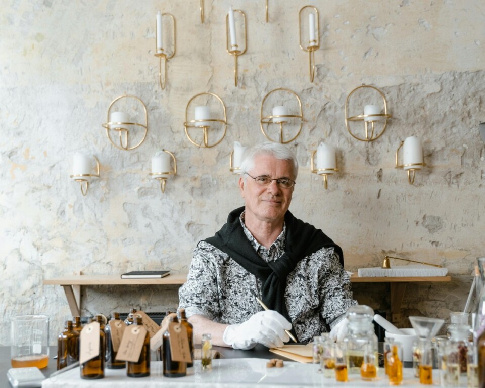 Mand ved duftbord med små parfumeflasker som cover til artikel om Armani parfume til mænd