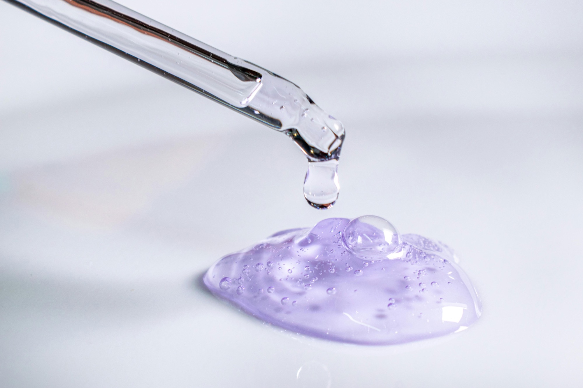 Pipette drypper transparent serumgel på lys overflade