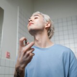 Mand der påfører parfume foran spejlet som cover til artikel om Hugo Boss parfume til mænd