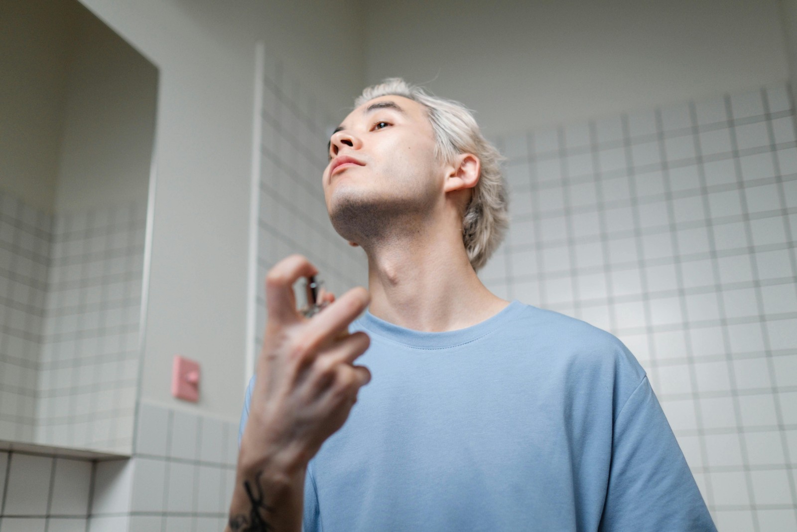 Mand der påfører parfume foran spejlet som cover til artikel om Hugo Boss parfume til mænd