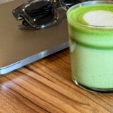 Matcha, laptop og solbriller på et arbejdsbord