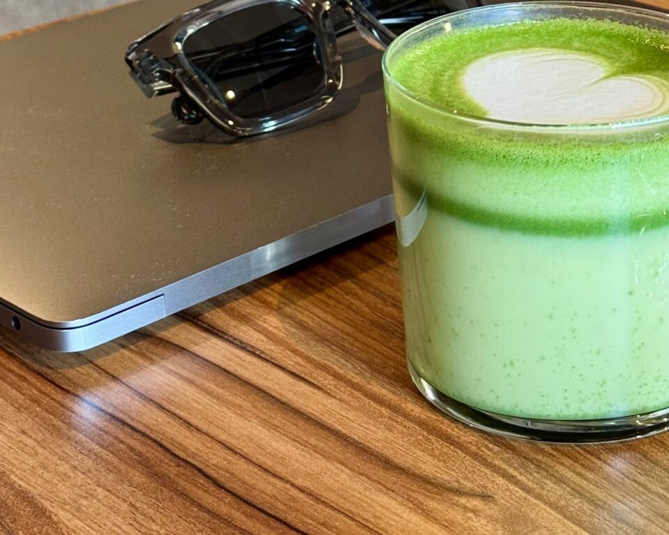 Matcha, laptop og solbriller på et arbejdsbord