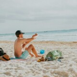 Mand på stranden med sol og bar hud