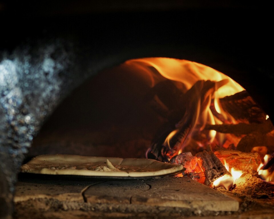 Pizza i stenovn med flammer og varm bund