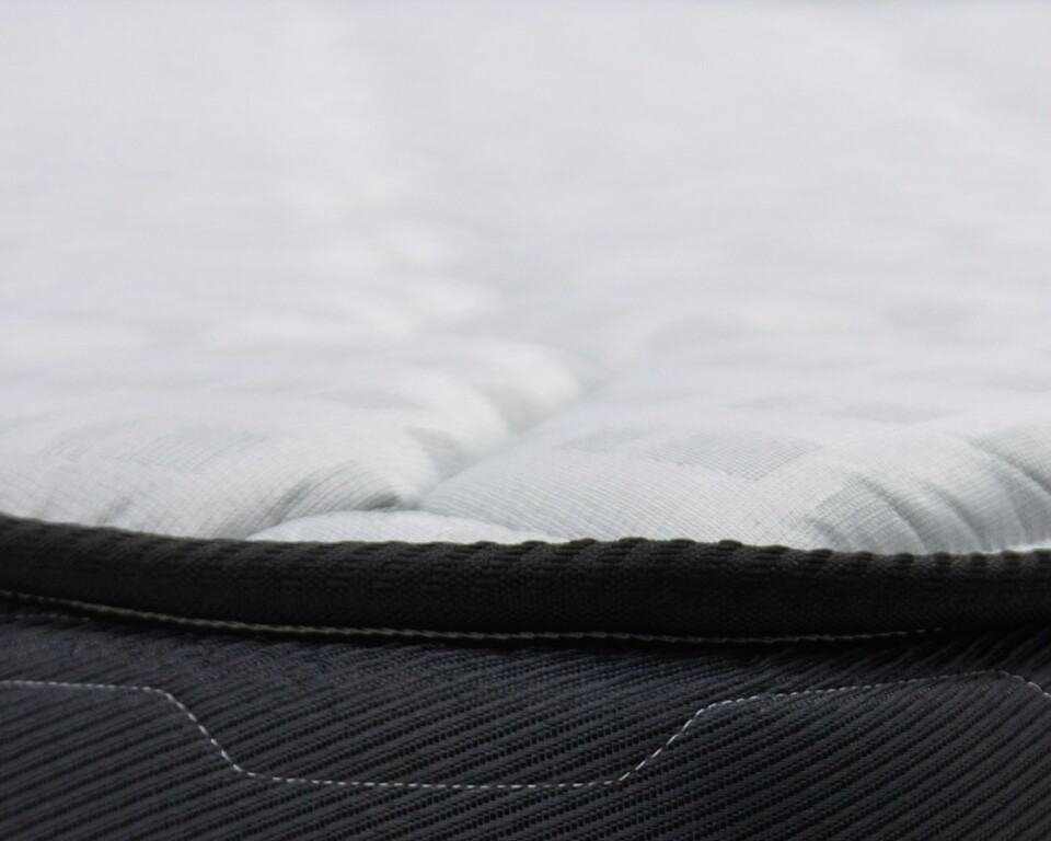Close-up af topmadras og mørk madras i et roligt soveværelse