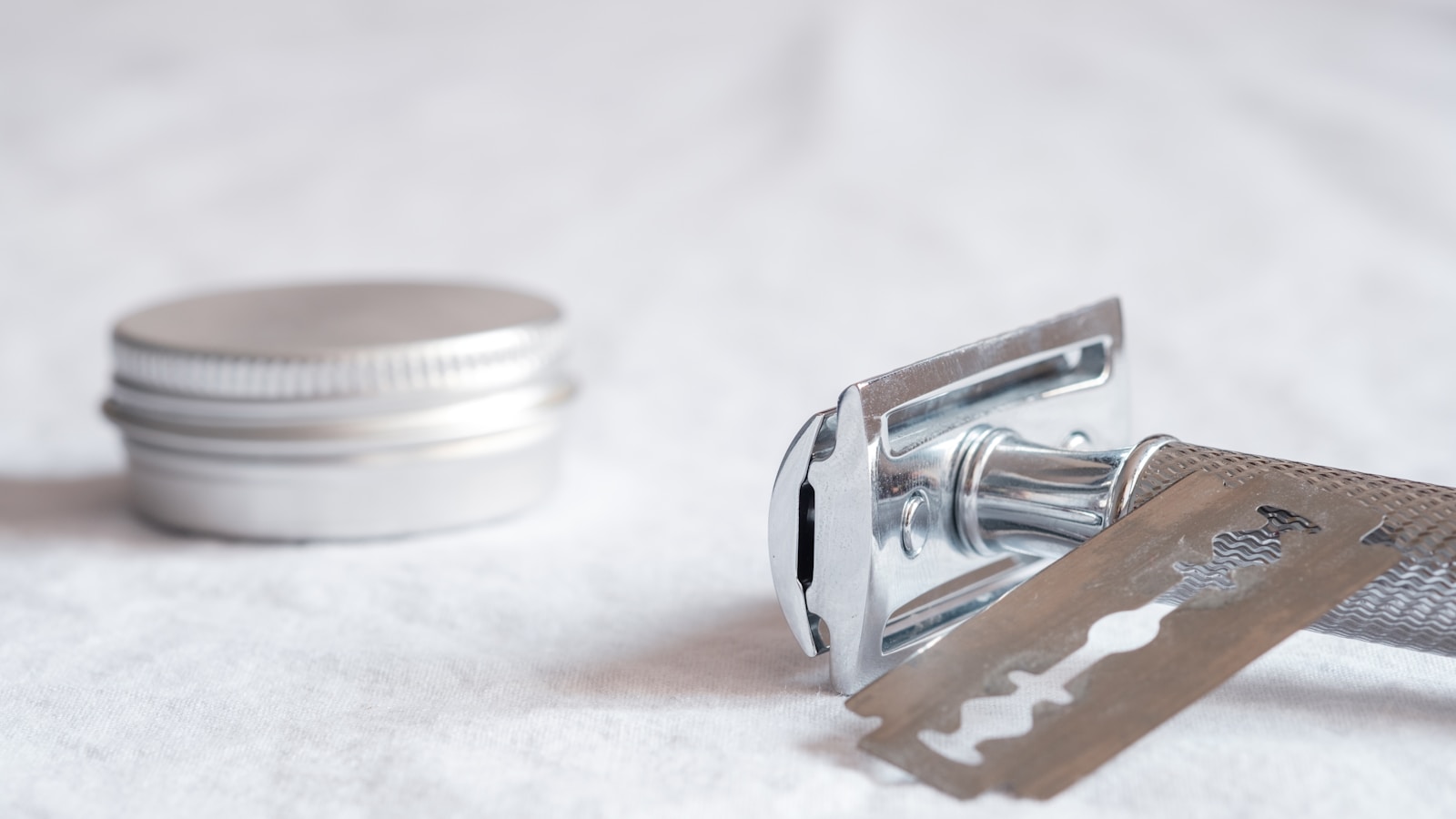 Safety razor og barberblad på lyst stof