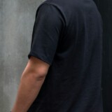 Mand i sort T-shirt foran beton og sort facade