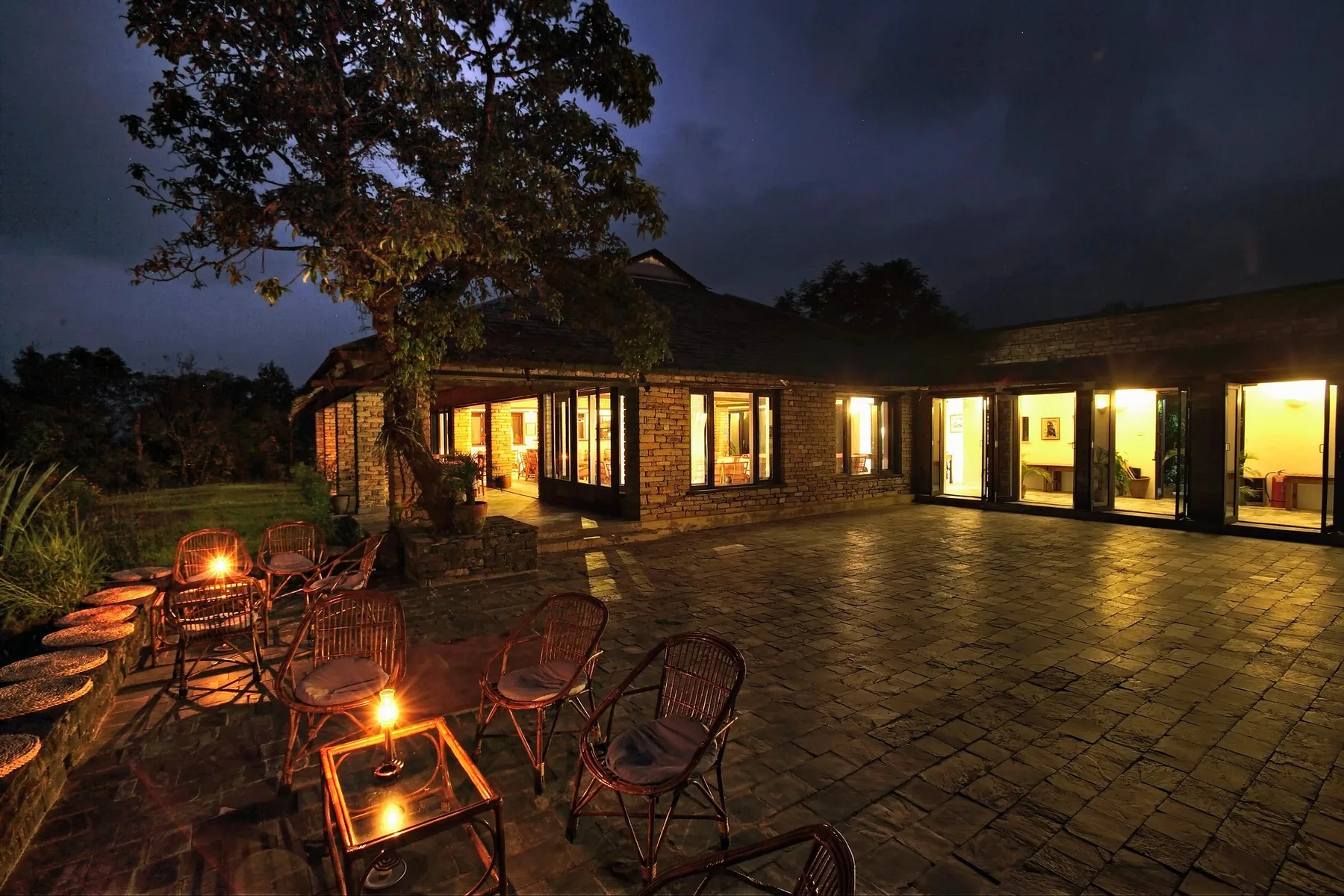 Oplyst hovedlodge om aftenen på Tiger Mountain Pokhara Lodge