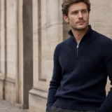 Mand i navy half-zip trøje i en klassisk europæisk by