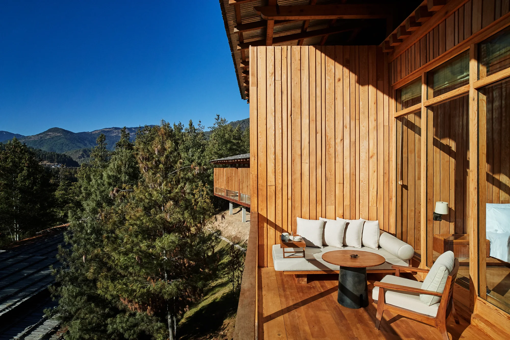 Træterrasse mod fyrreskoven hos Six Senses Bumthang i Bhutan