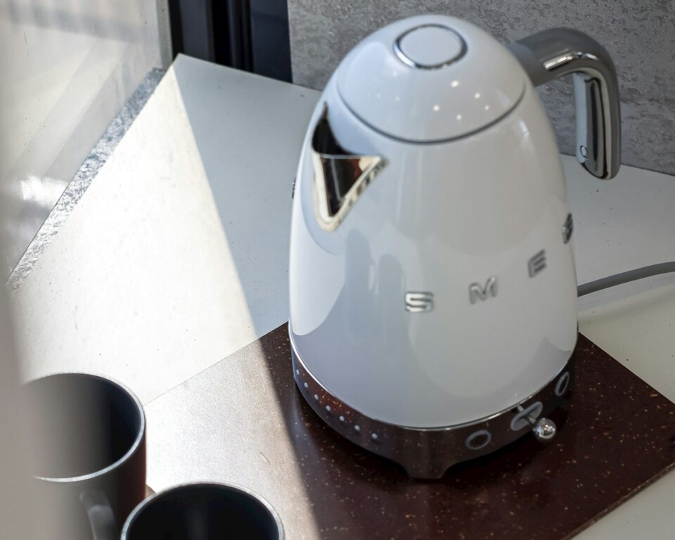 Hvid Smeg elkedel på køkkenbord med kopper og vindueslys