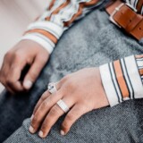 Stribet skjorte, grå bukser og brunt læderbælte i tæt outfitdetalje