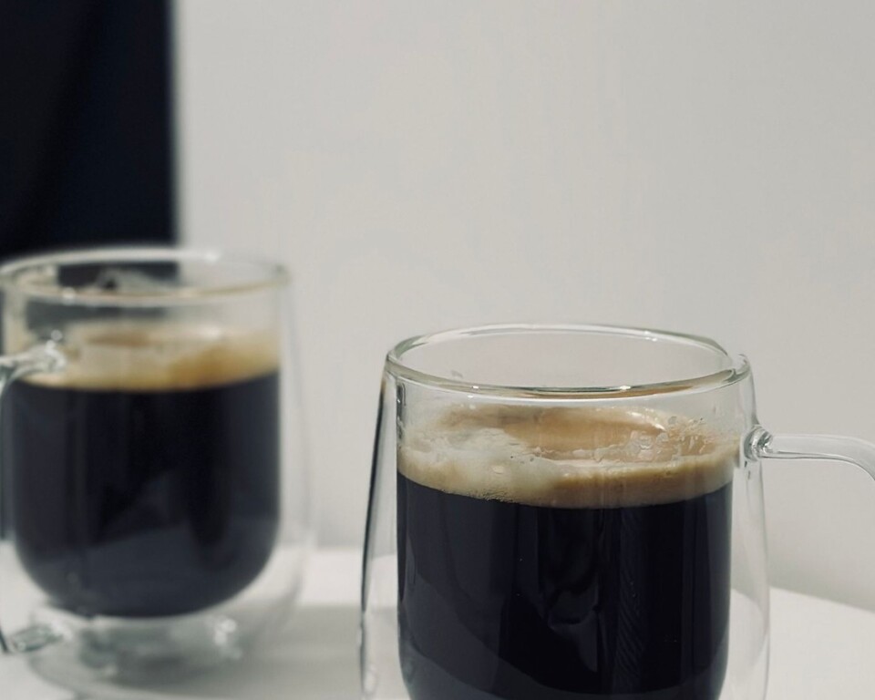 To dobbeltvæggede kaffeglas på et lyst bord