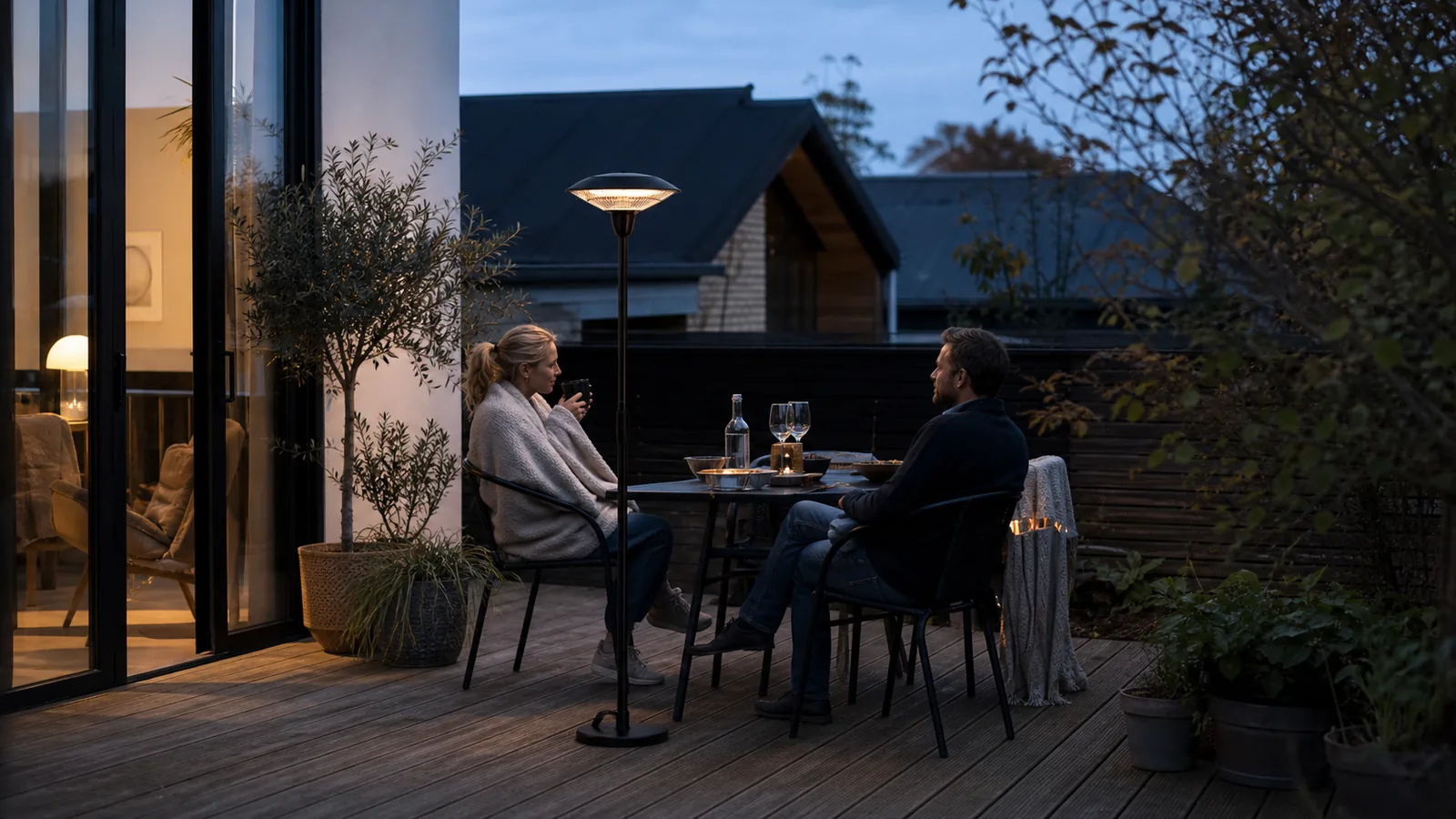 Par på en dansk terrasse en kølig sensommeraften med en diskret terrassevarmer