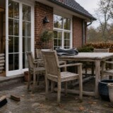 Dansk terrasse med havemøbler, tørre hynder, krukker og et foldet overtræk før vinter