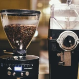 To elektriske kaffekværne med kaffebønner i en varm café