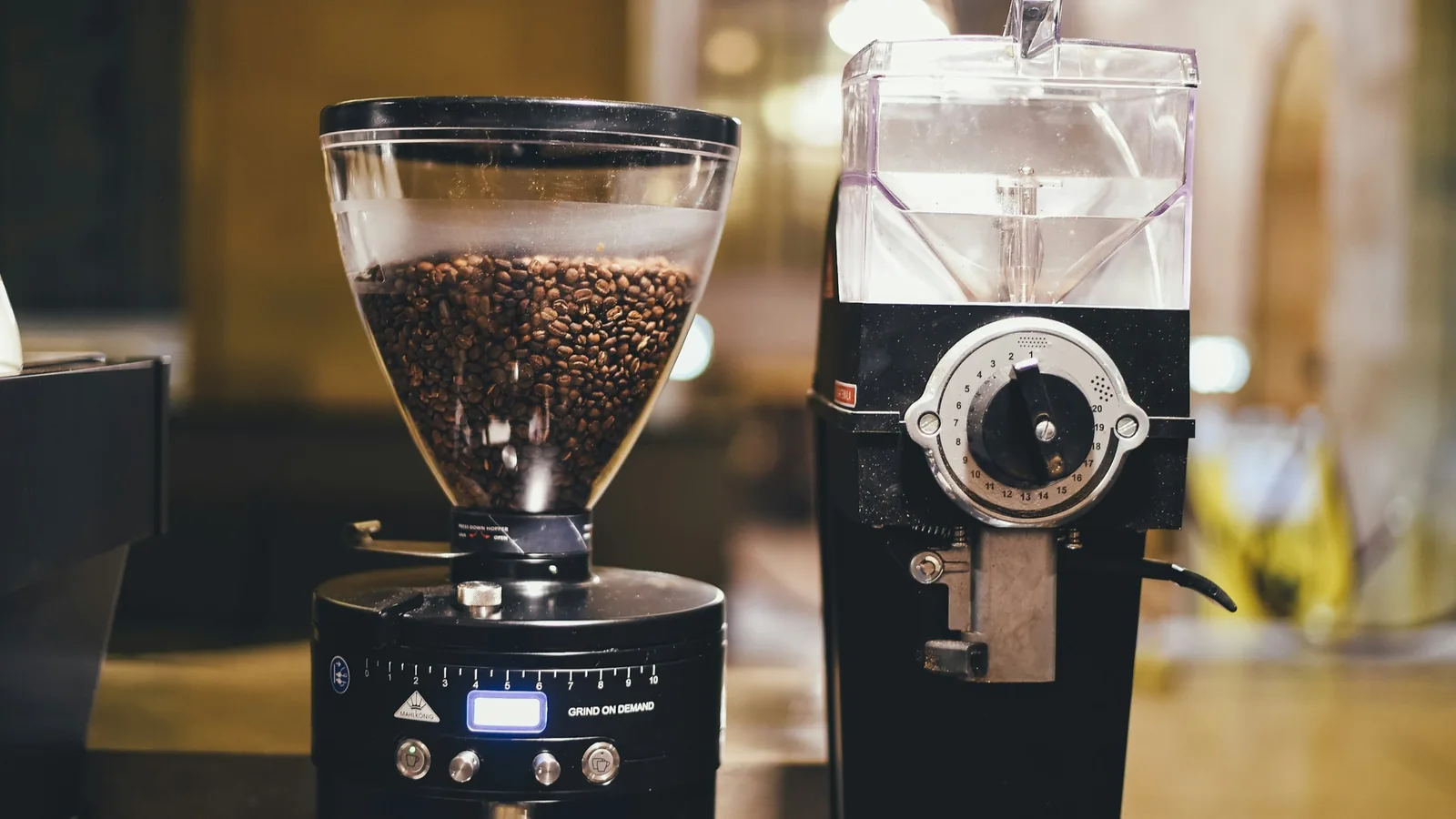 To elektriske kaffekværne med kaffebønner i en varm café