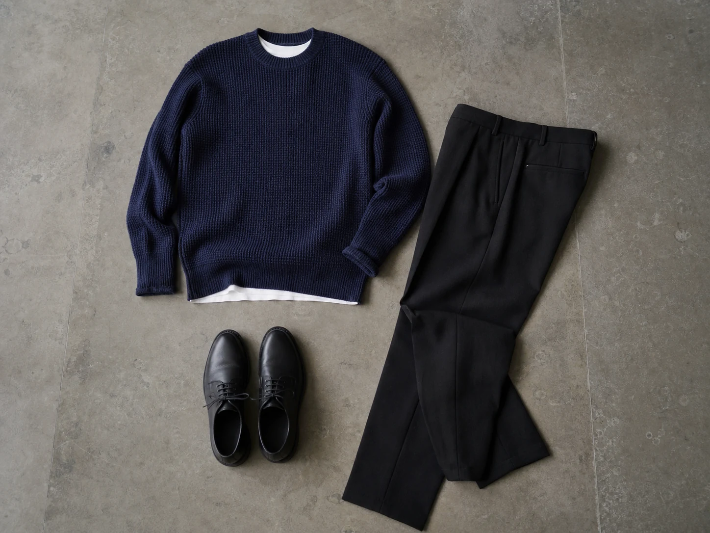 Herreoutfit i sort og navy med hvid separator, navy strik og sorte bukser