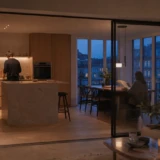 Åbent køkken med glasparti mellem madlavning, spiseplads og stue