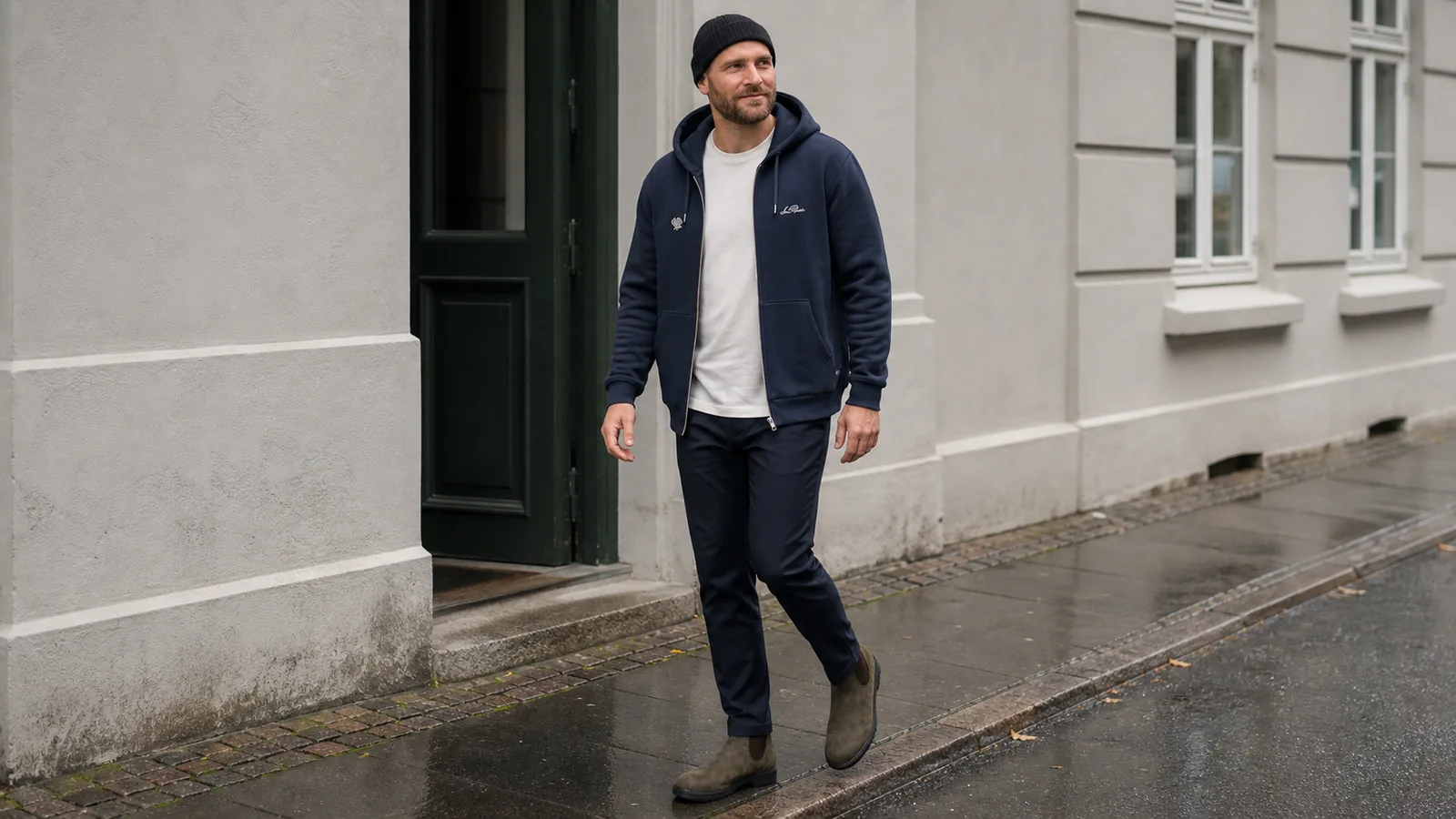 Joen i navy zip-hoodie, hvid T-shirt, sort hue, navy bukser og brune Chelsea boots