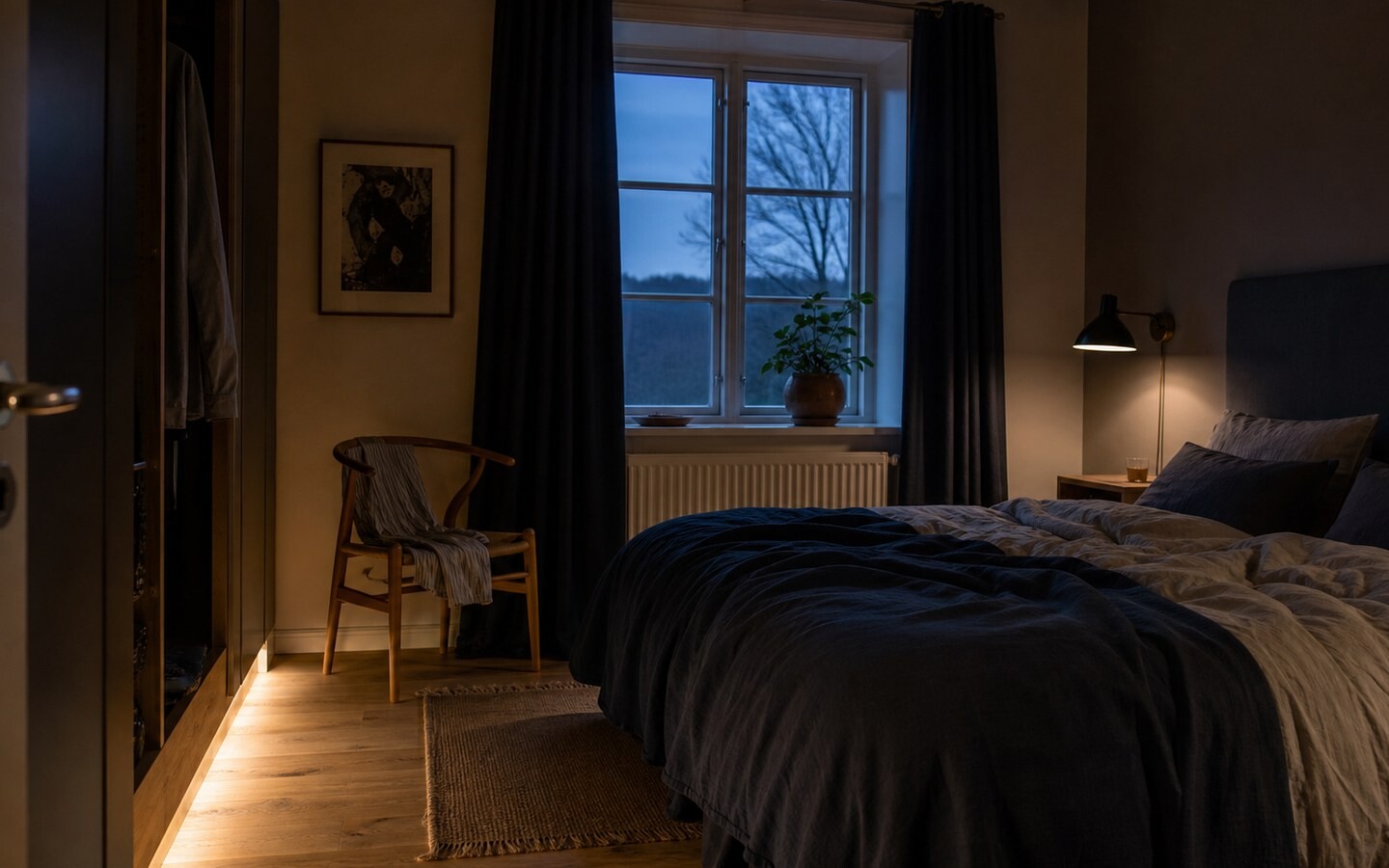 Soveværelse ved blå time med afskærmet læselys og lav belysning langs gulvet