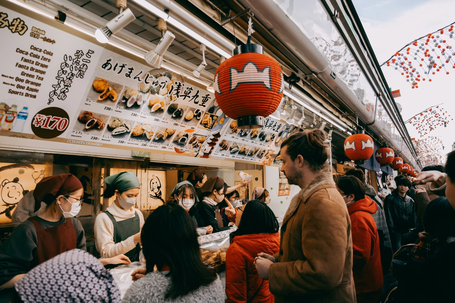 Lille madbod med gæster på et livligt marked i Tokyo