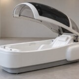 AI-visualisering af en åben badekapsel med hvidt sæde og buet sort og hvid overdækning.