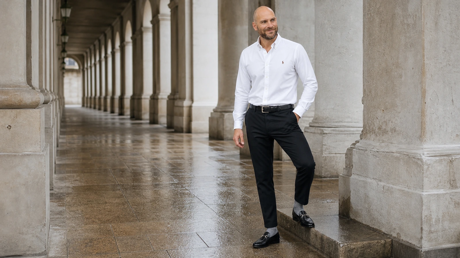 Joen i hvid Oxford-skjorte, sorte bukser og loafers med synlige grå ribstrømper