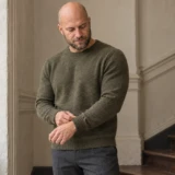Joen i olivengrøn striktrøje ved en trappe